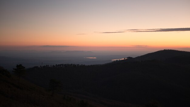 Splendido scenario di un paesaggio con montagne con il tramonto mozzafiato sullo sfondo