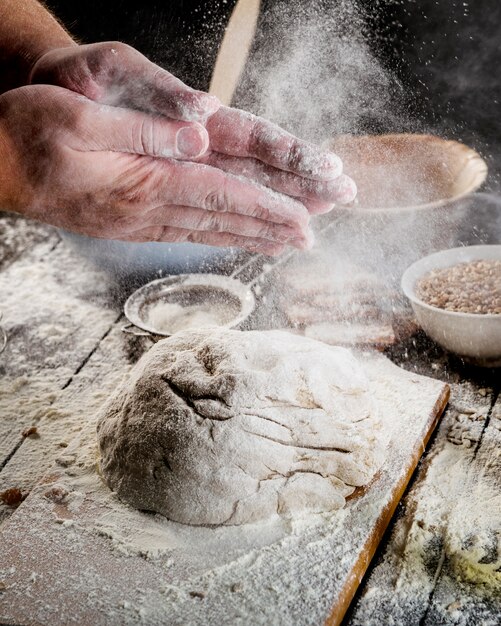 Spolverare a mano con la farina sulla pasta sopra il tavolo