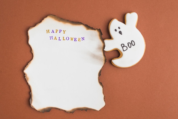 Spook gingerbread vicino al foglio di carta in fiamme