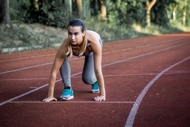 sport bella ragazza sul tapis roulant pronto per eseguire un grande stadio, primo piano