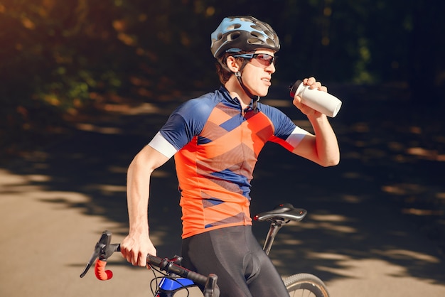 Sport uomo in sella a bici nella foresta di estate