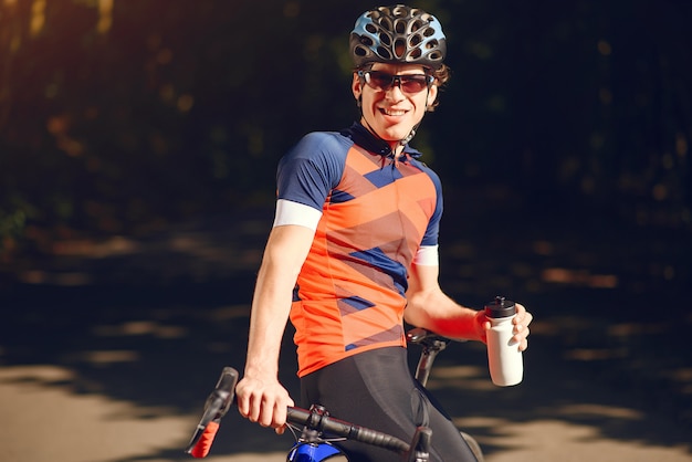 Sport uomo in sella a bici nella foresta di estate