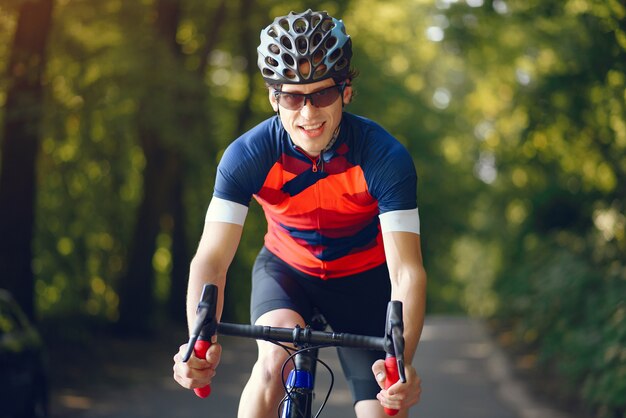 Sport uomo in sella a bici nella foresta di estate