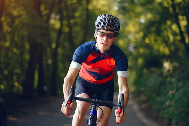 Sport uomo in sella a bici nella foresta di estate