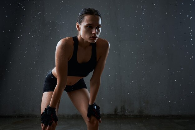 Sportiva che posa in abiti sportivi isolati su gray