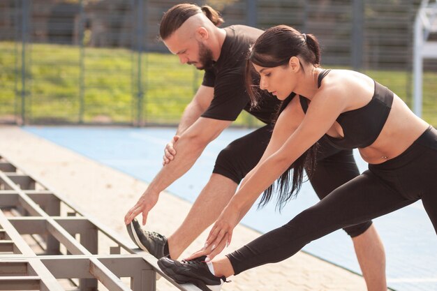 Sportivi del lavoro di gruppo che allungano insieme