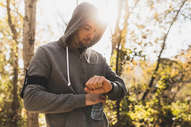 Sportivo controllando l&#39;orologio prima di iniziare a correre