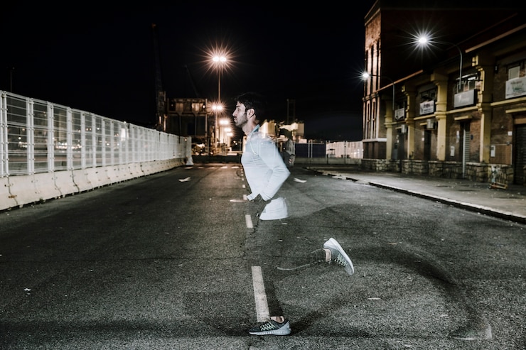 Foto gratuito sportivo sfocato nella notte sulla strada
