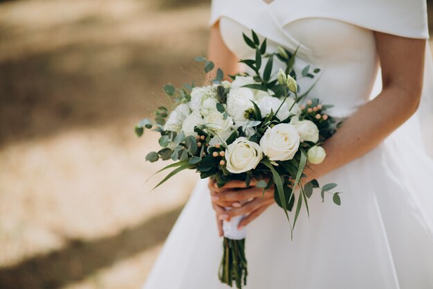 Sposa che tiene il suo bouquet da sposa