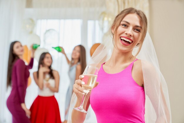 Sposa con champagne che ride all'addio al nubilato