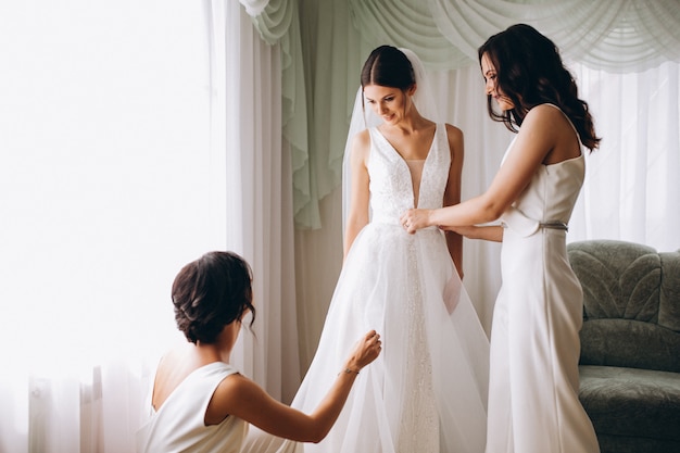 Sposa con damigelle preparando per il matrimonio