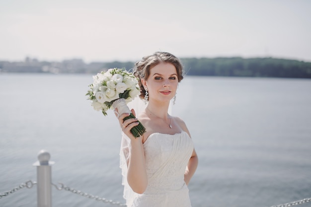 Sposa con un mazzo di fiori in un lago