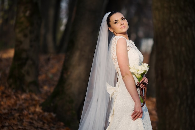 Sposa con un mazzo di fiori in una foresta