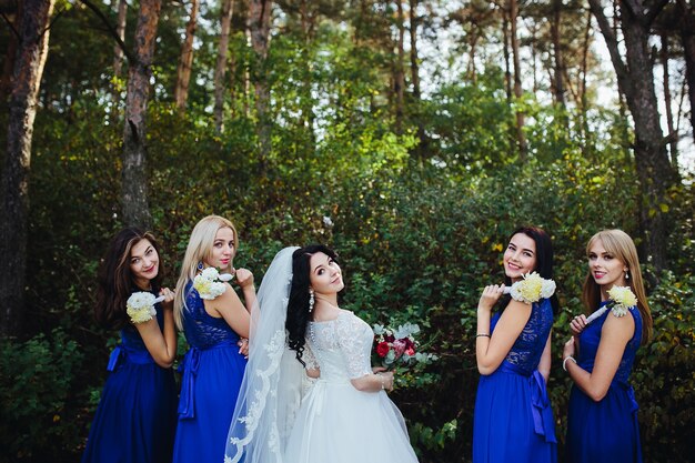 Sposa e damigella d&#39;onore guardando sorridente macchina fotografica