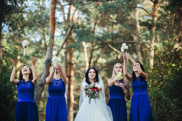 Sposa e damigelle che lanciano bouquet