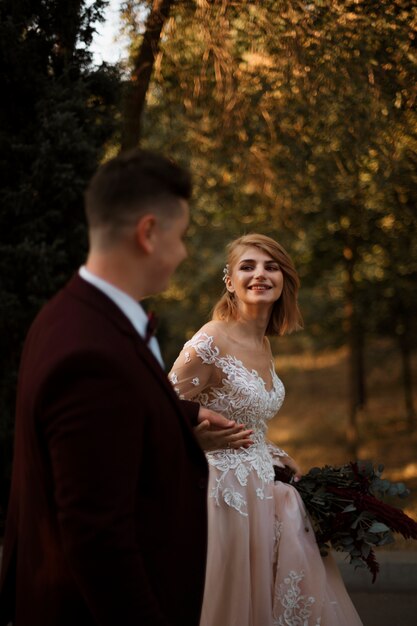 Sposa e sposo di vista laterale che si tengono per mano