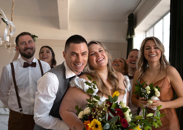 Sposa e sposo felici con persone alla cerimonia nuziale