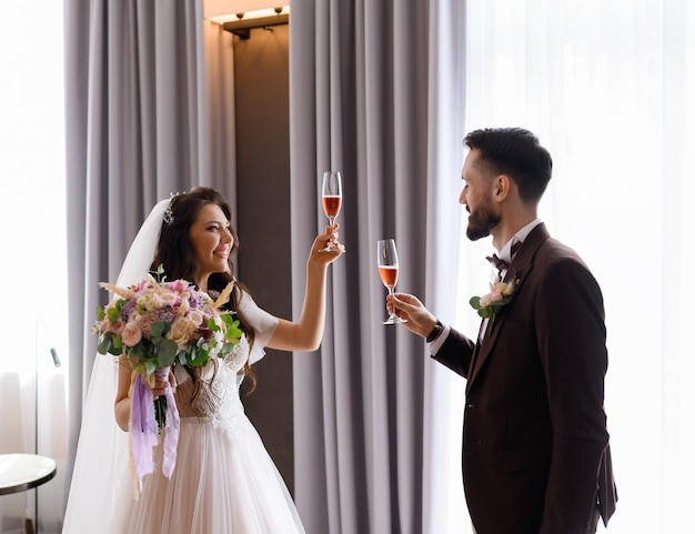Spose che celebrano il giorno delle nozze con champagne