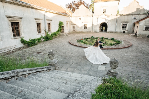 Spose felici ballano vicino al castello