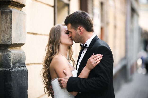 Sposo baciare bella sposa sulla strada