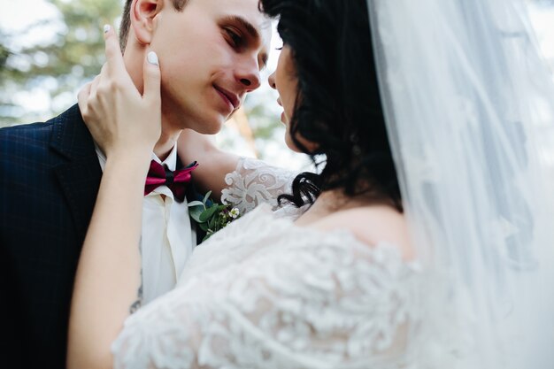 Sposo e sposa abbracciando in piedi fuori