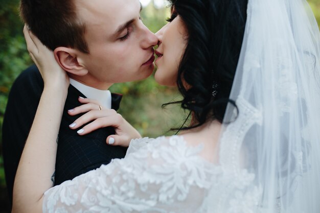 Sposo e sposa baciare in piedi fuori