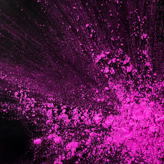 Spruzzi di particelle di polvere rosa su sfondo nero