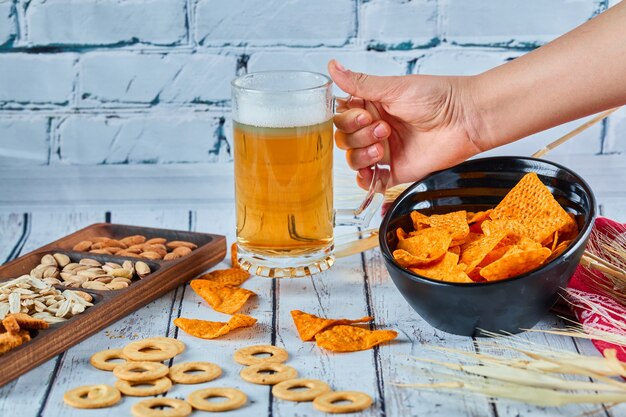 Spuntini, patatine fritte e birra assortiti sul tavolo blu. Tavolo per gruppo di amici.