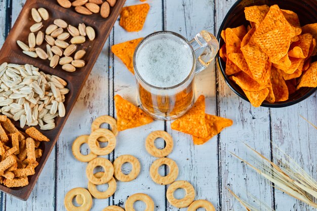 Spuntini, patatine fritte e birra assortiti sul tavolo blu. Tavolo per gruppo di amici.