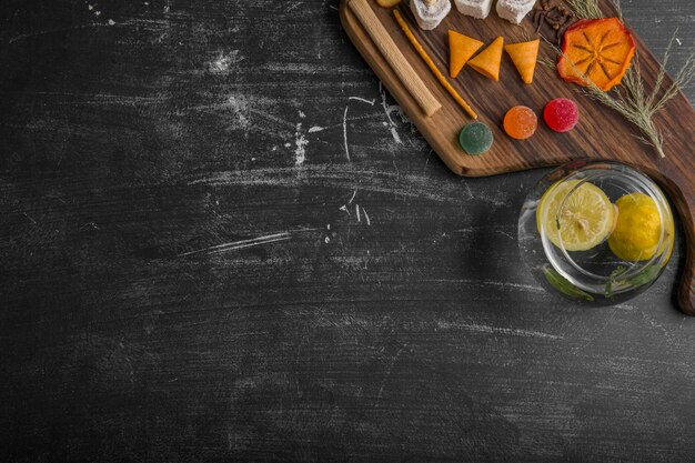 Spuntino e spianatoia con patate in acqua su sfondo nero, vista dall'alto