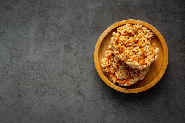 Spuntino tailandese; KAO TAN o cracker di riso in ciotola di legno