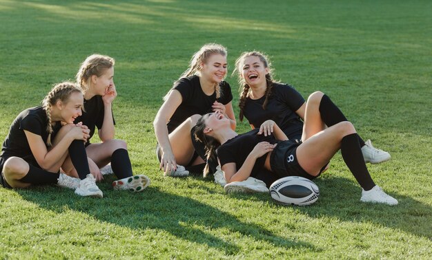 Squadra femminile di rugby che si siede sull'erba