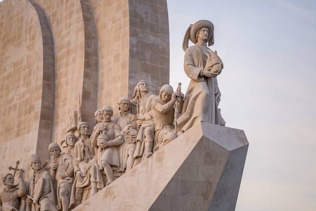 Statue sul monumento delle scoperte sotto la luce del sole a Lisbona in Portogallo