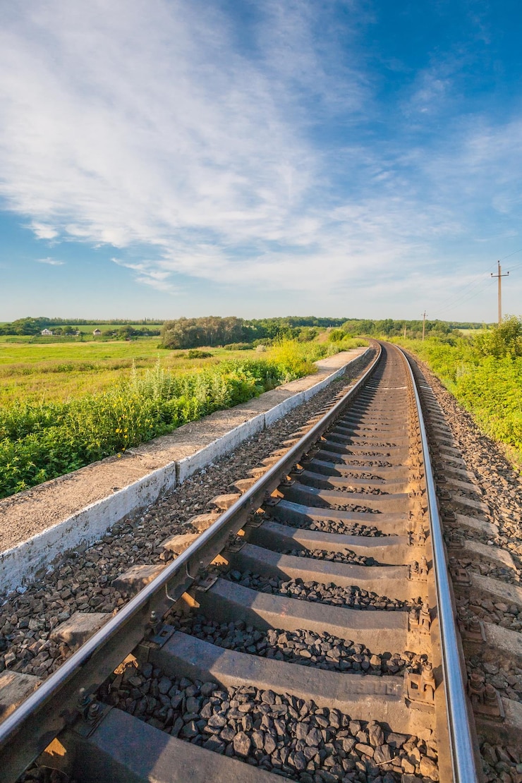 Foto gratuito stazione ferroviaria contro il bel cielo al tramonto paesaggio industriale con la ferrovia colorato cielo blu nuvoloso