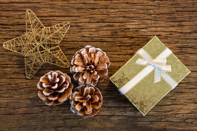Stella di Natale, pigne e un regalo su un tavolo di legno