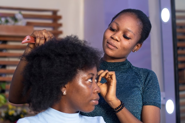 Stilista donna che si prende cura dei suoi capelli afro cliente