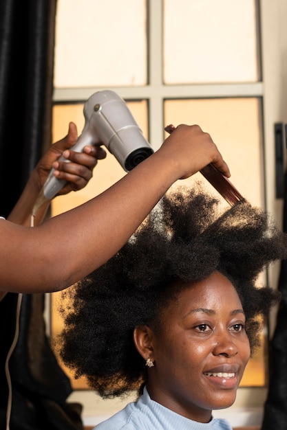 Stilista donna che si prende cura dei suoi capelli afro cliente