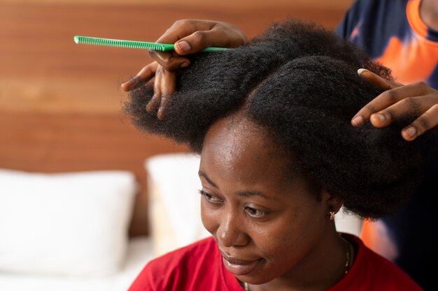 Stilista donna che si prende cura dei suoi capelli afro cliente