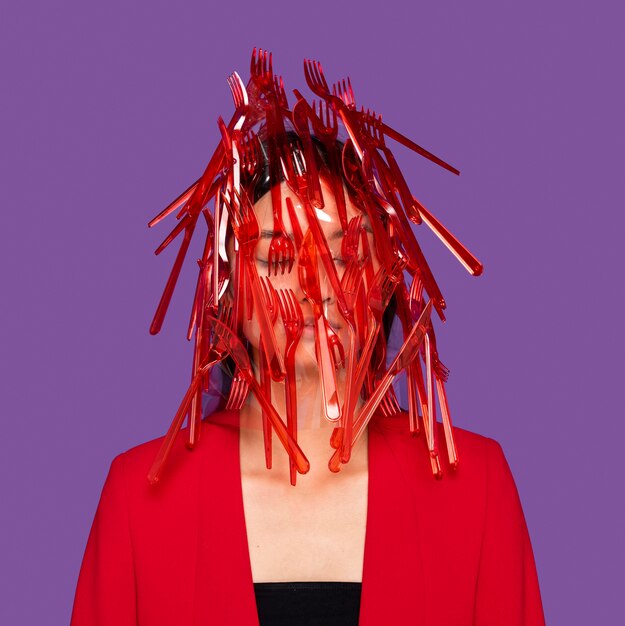 Stoviglie in plastica rossa sul viso della donna
