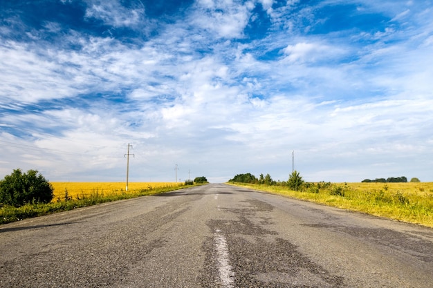 Strada di campagna tra i campi Bel cielo nuvoloso