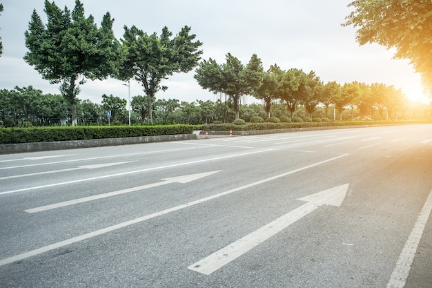 strada di cemento con le frecce al sorgere del sole