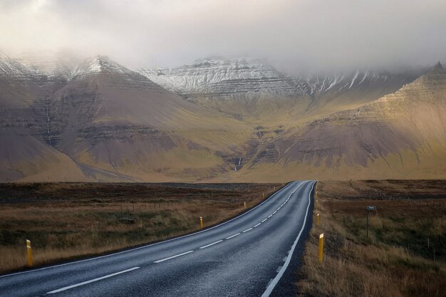 Strada lunga e stretta con bellissime colline e montagne coperte di nebbia