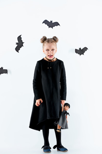 Strega bambina in abito lungo nero e accessori magici. Halloween