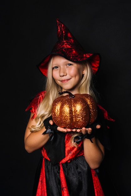 Strega carina che mostra la zucca