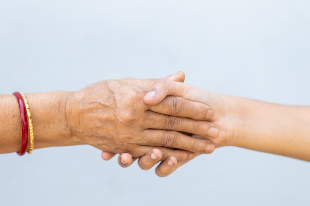 Stringere la mano su un muro grigio