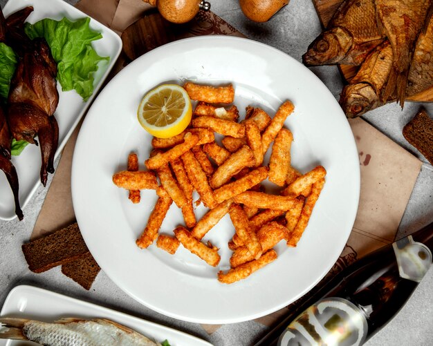 Strisce di formaggio fritto croccanti guarnite con limone