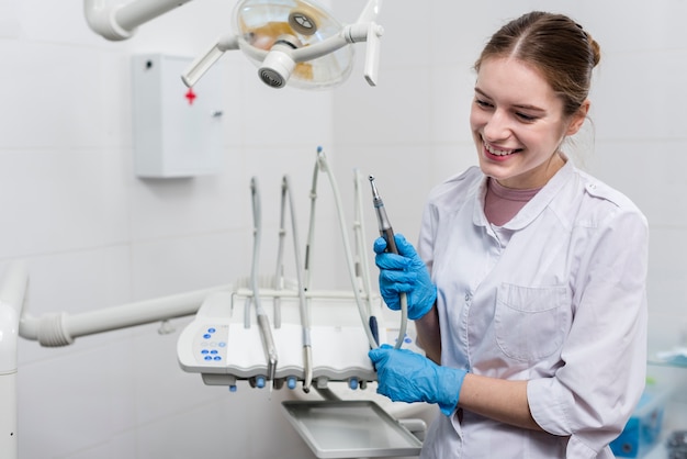 Strumenti di tenuta del dentista della giovane donna