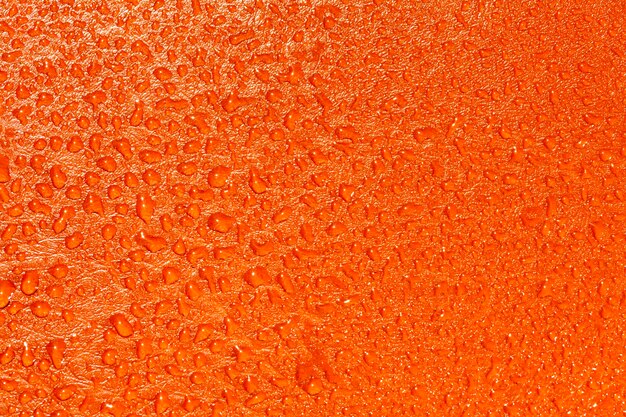 Struttura arancione con gocce d&#39;acqua