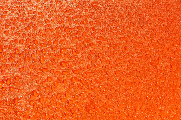 Struttura arancione con gocce d&#39;acqua