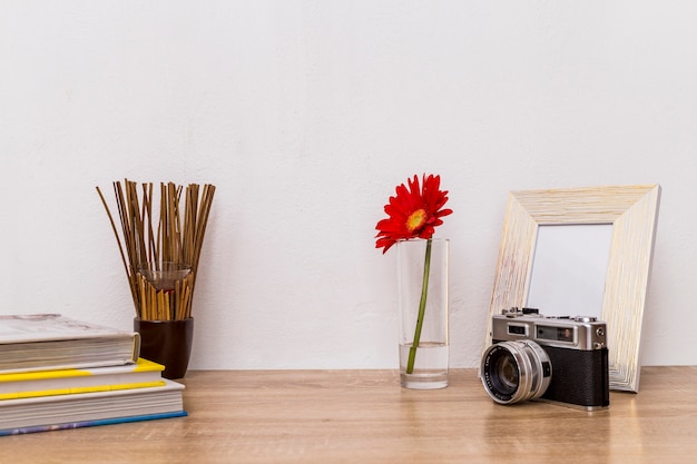 Struttura della foto del fiore della macchina fotografica e libri sulla tavola